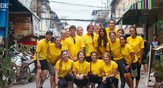 A group of gap year students in a Thai street, all wearing yellow GapGuru t-shirts - GapGuru