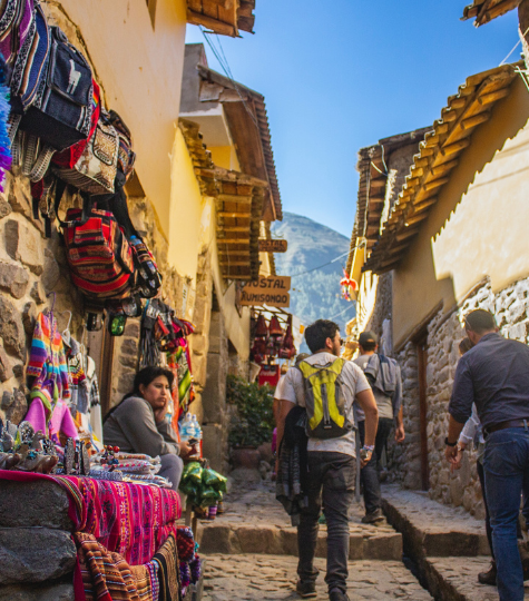 Colourful tight street in Cusco with street vendors and backpackers - GapGuru