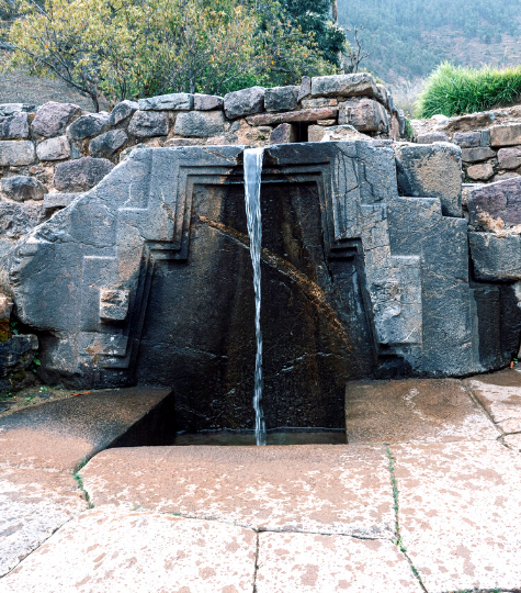 An ancient stone water fountain at the Ollantaytambo ruins - GapGuru
