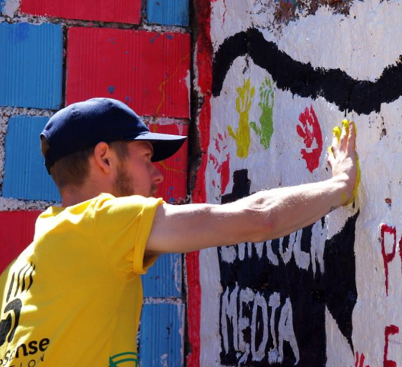 A GapGuru gap year student leaving his handprint on the wall of a school ground in Peru - GapGuru