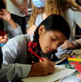 An Indian school girl writing at her desk - GapGuru