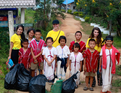 GapGuru volunteers posing with kids and black bin bags from cleaning up the community